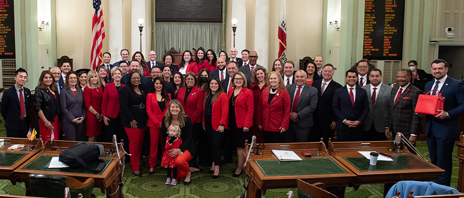 Group photo of assemblymembers, many wearing red clothing