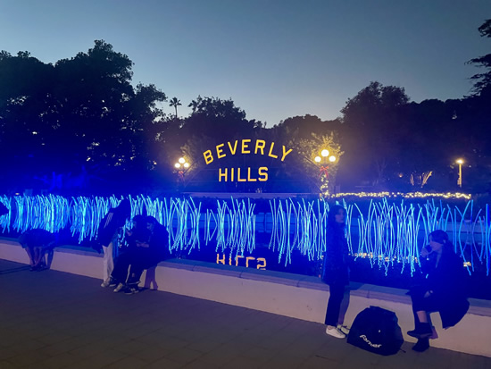 Multiple blue tube lights in front of illuminated Beverly Hills sign