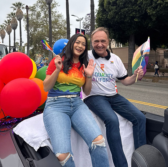 Asm. Zbur and Asm. Caloza waving flags from their parade car