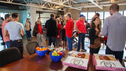 Constituents mingling, with snacks on table in foreground