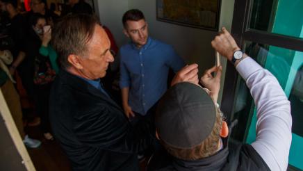Asm. Zbur assisting rabbi with placement of a mezuzah