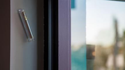 A mezuzah affixed to wall, next to window at the District Office entrance