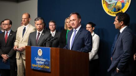 Asm. Zbur at podium, speaking, as Speaker Rivas and other officials listen on