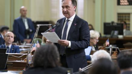 Asm. Zbur standing and speaking into microphone on the Assembly Floor