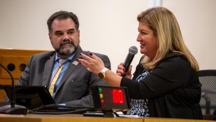 Panelist speaks as fellow panelist listens on