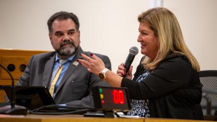 Panelist speaks as fellow panelist listens on