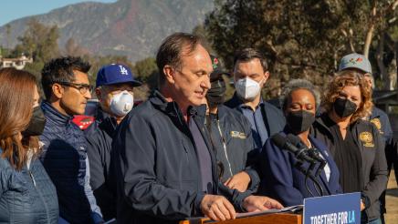 Asm. Zbur at podium, speaking, as Speaker Rivas and other assemblymembers stand in support